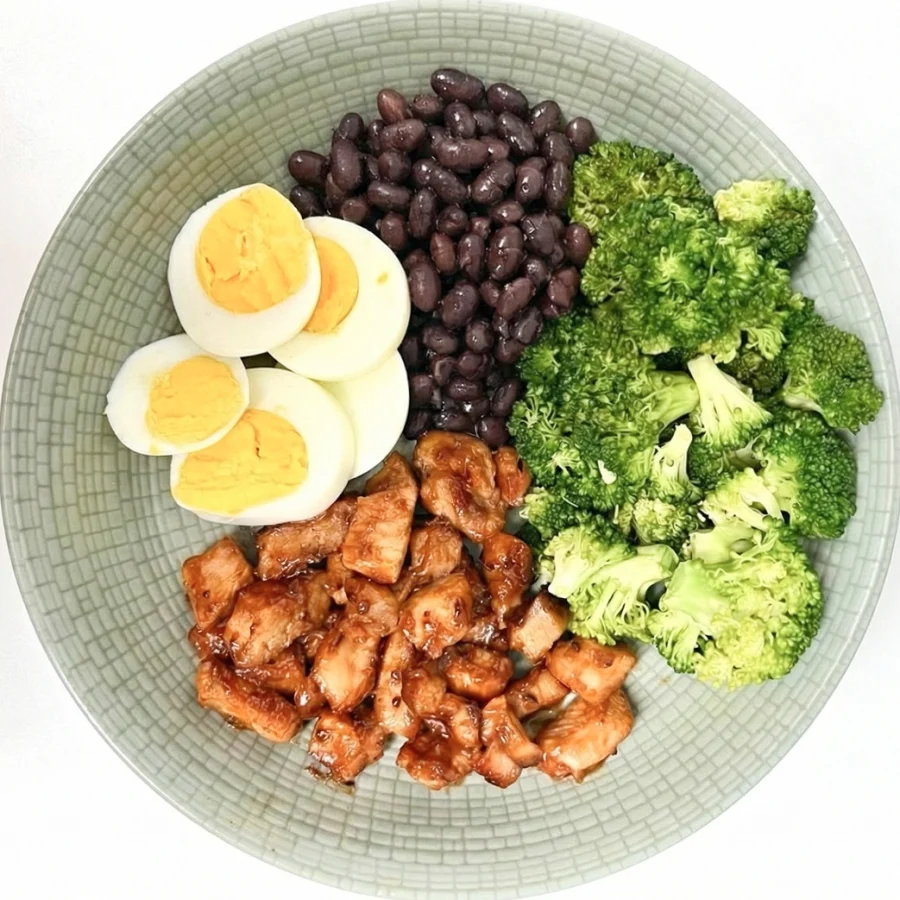 Balanced plate with chicken, eggs, black beans, and broccoli